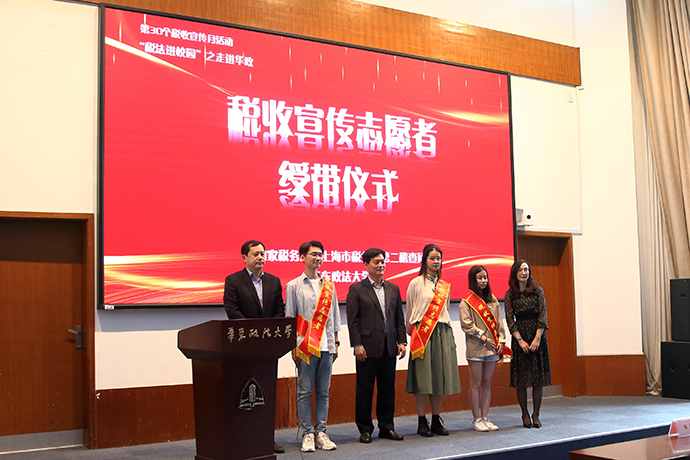 第二稽查局局领导与华东政法大学校领导共同为学生志愿者颁发税收宣传志愿者绶带。